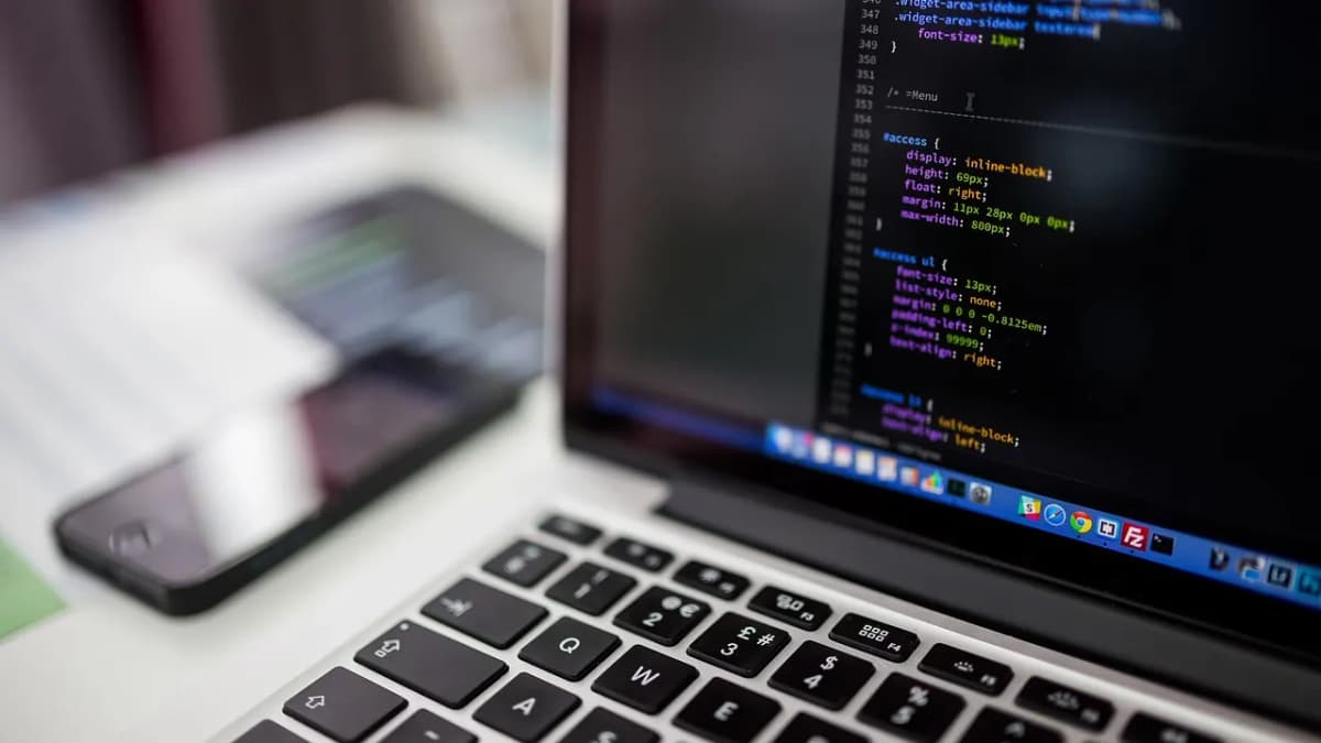 Laptop showing code in an editor next to a smartphone