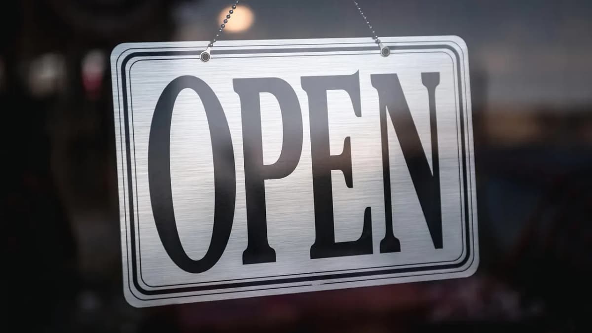 Open sign hanging in a shop window