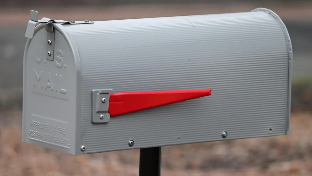 Grey metal mailbox with a red flag raised