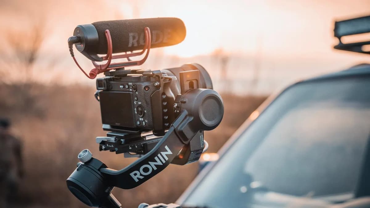 Mirrorless camera with a microphone on a gimbal at sunset