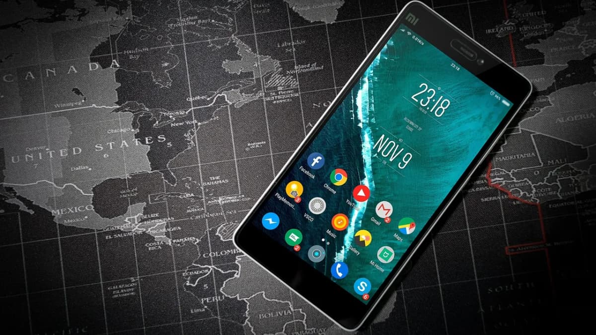 Android smartphone showing app icons lying on a dark world map
