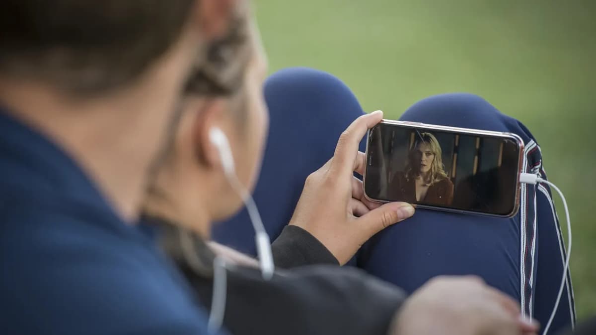Person holding a smartphone horizontally and watching a video