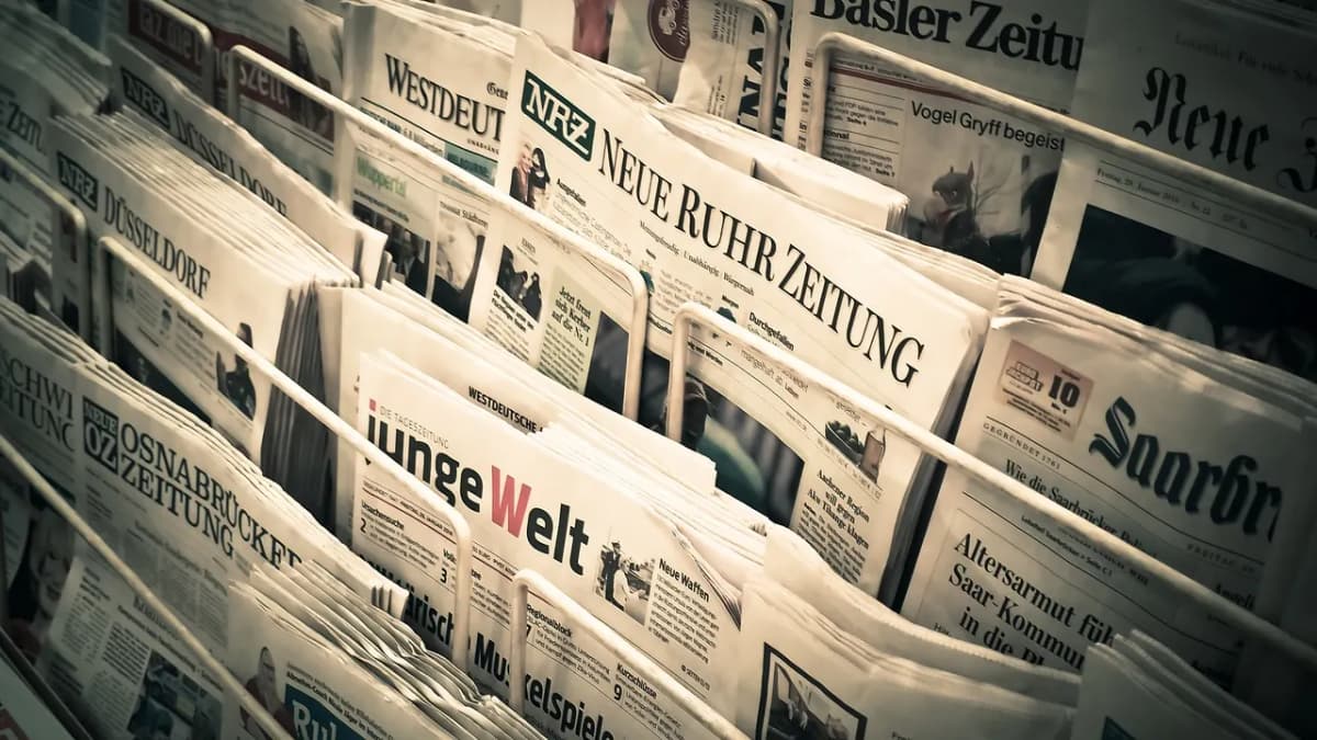 Rows of printed newspapers on a news stand