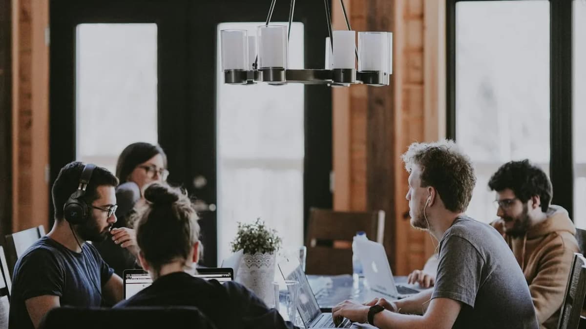 Small startup team working together on laptops around a table